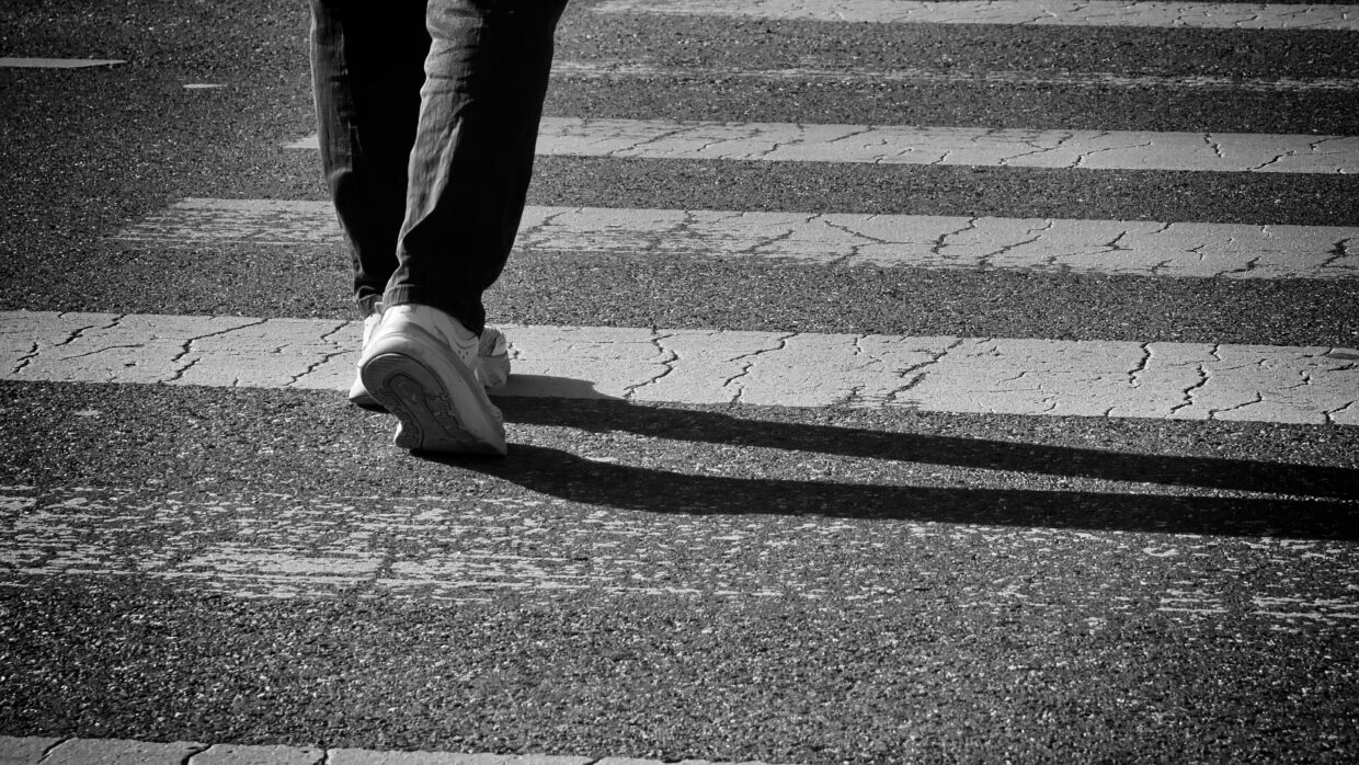 Frau überquert eine Straße auf dem Zebrastreifen